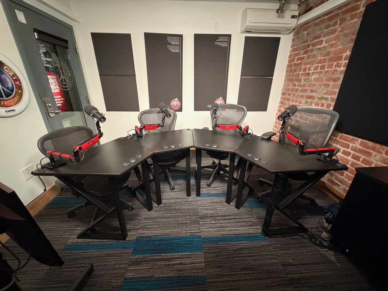 A meeting room with a U-shaped table, six chairs, and audio equipment.