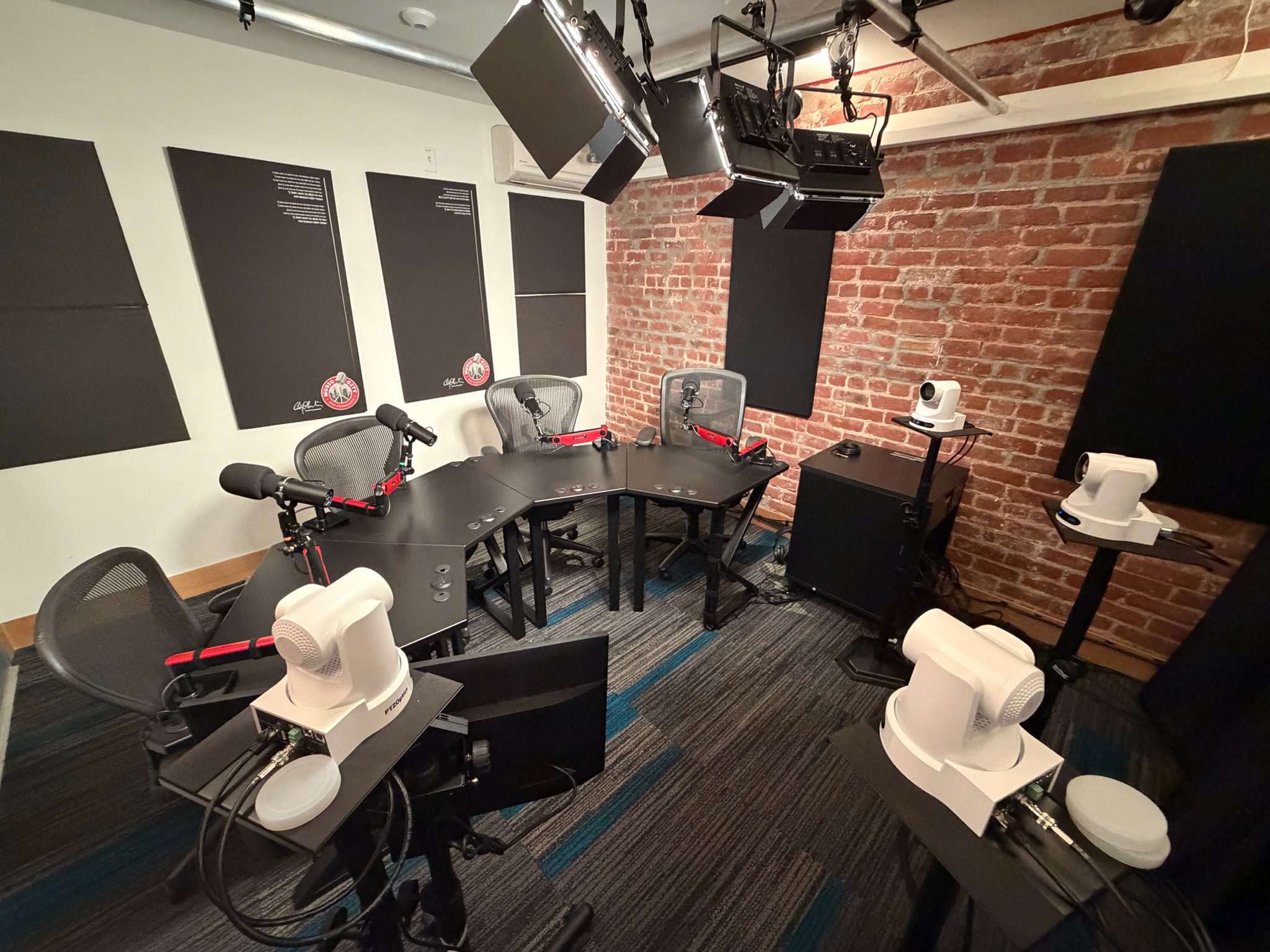 A professional recording studio with a U-shaped table and audio equipment.