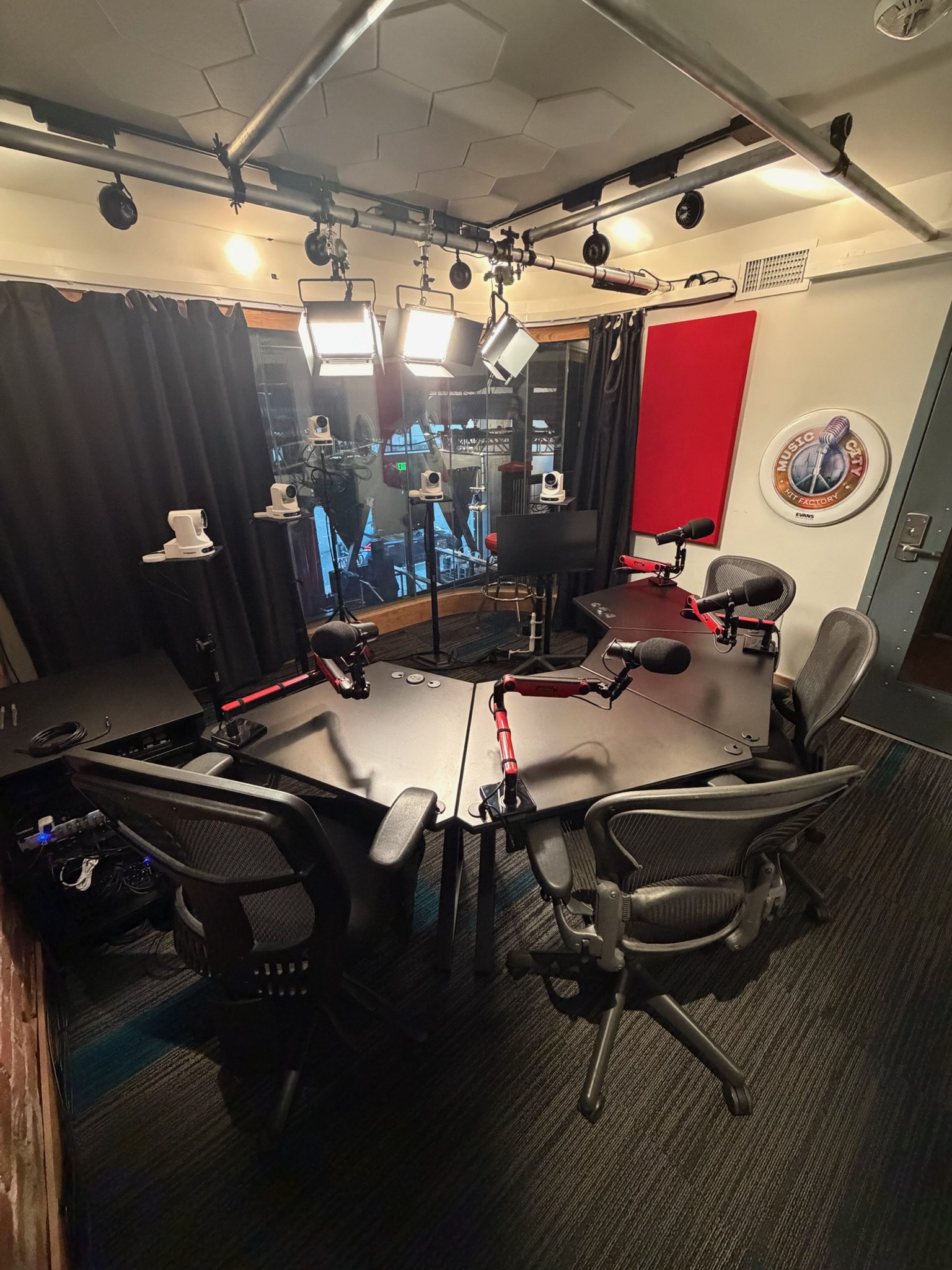 A soundproof meeting room with a table, chairs, microphones, cameras, and a computer.
