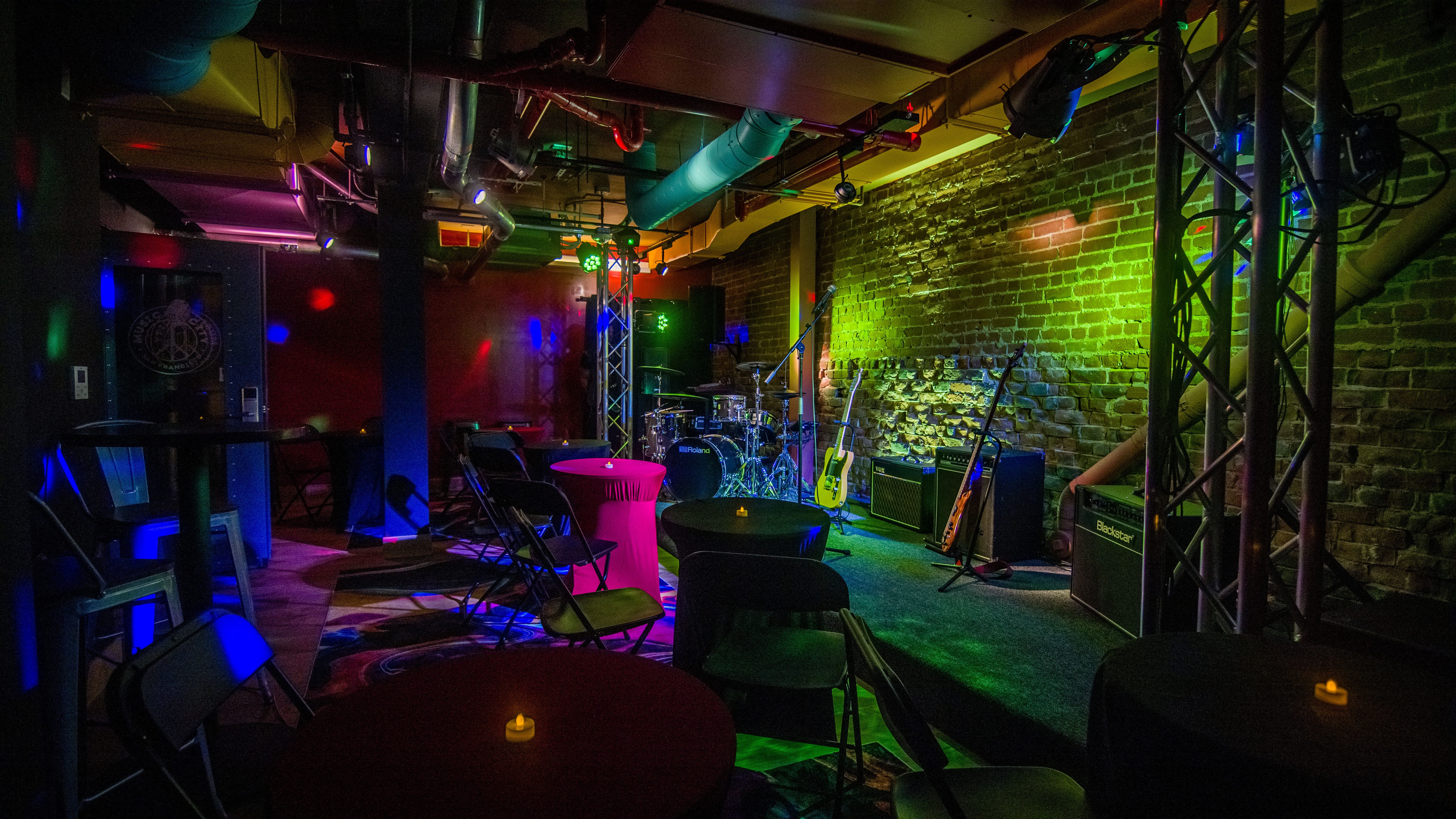 a dimly lit room with a stage and musical equipment