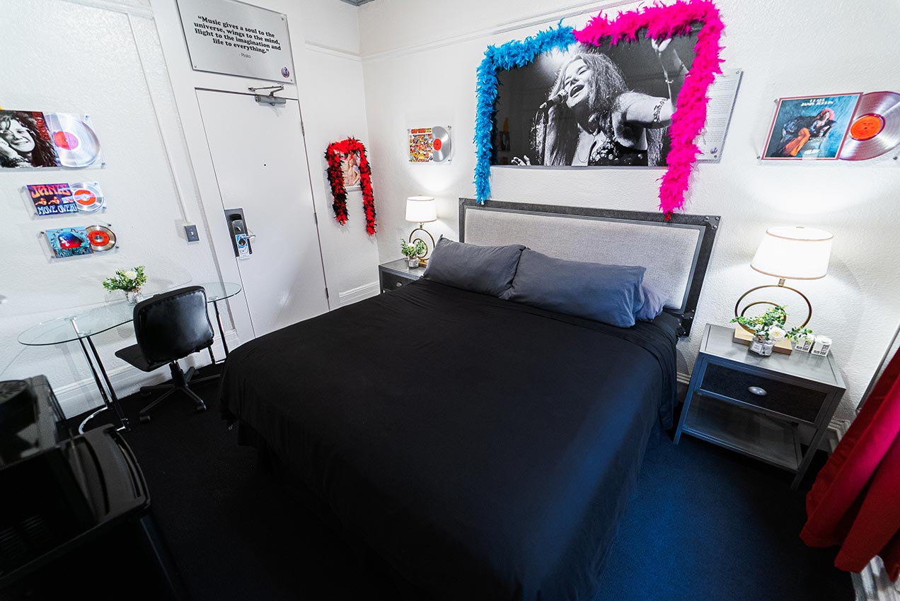 A hotel room with a bed, desk, and chair